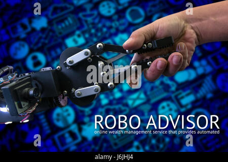 Cyber comunicazione e concetti di robotica. robo advisor concetto. Robot e umani ingegnere tenendo la mano con handshake e la sfocatura wealth management icone Foto Stock