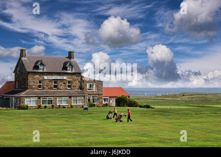 Due lady golfisti a piedi nella parte anteriore del Whitby Golf Club con i loro carrelli da golf, Whitby, North Yorkshire, Inghilterra, Regno Unito, in una bella giornata di primavera con una soleggiata b Foto Stock