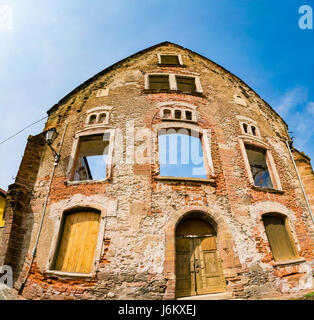 La facciata di un vecchio mattone distrutto casa Foto Stock