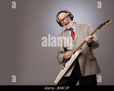Happy funny man senior di suonare una chitarra elettrica Foto Stock