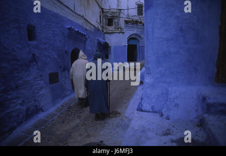 17.11.2010, Chefchaouen, Marocco, Africa - La gente del posto a piedi attraverso il labirinto di vicoli e il passato di colore bianco-blu colorate facciate di casa nella medina. Foto Stock