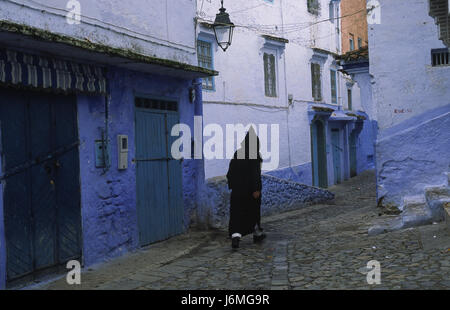 18.11.2010, Chefchaouen, Marocco, Africa - un uomo cammina attraverso il labirinto di vicoli e il passato di colore bianco-blu colorate facciate di casa nella medina. Foto Stock