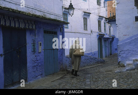 18.11.2010, Chefchaouen, Marocco, Africa - un uomo cammina attraverso il labirinto di vicoli e il passato di colore bianco-blu colorate facciate di casa nella medina. Foto Stock