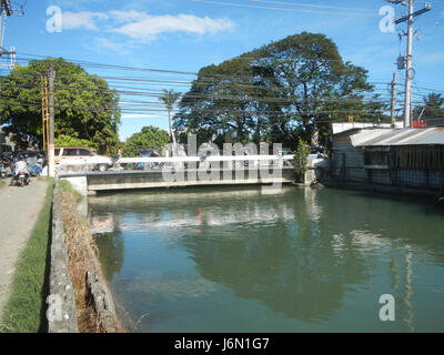 Questa immagine mostra il ponte di irrigazione attraverso il torrente a Bagong Nayon, Baliuag, Bulacan, un'area essenziale per l'agricoltura locale. Il ponte svolge un ruolo cruciale nella distribuzione dell'acqua per scopi agricoli. Foto Stock