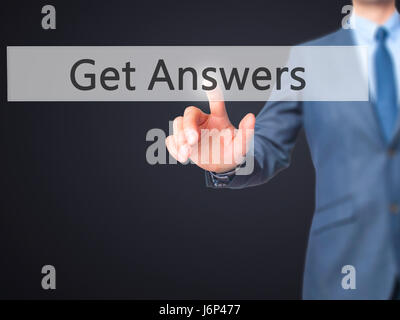 Ottieni le risposte - Imprenditore mano premere il pulsante sulla schermata virtuale di interfaccia. Business, concetto tecnologico. Stock Photo Foto Stock