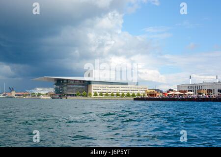 La Royal Opera House e la vicina isola di Papirøen, casa di Copenhagen Street Food con un drammatico sfondo cielo, Copenhagen, Danimarca Foto Stock