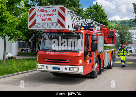 Iveco Magirus 160E30 la scaletta della piattaforma girevole carrello di una Svizzera vigili del fuoco. Scala e piattaforma retratto. Fireman in piedi accanto al veicolo. Foto Stock