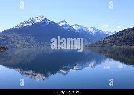Una meravigliosa splendida giornata di primavera in Loen in Sogn con alberi verdi e montagne innevate. Foto Stock