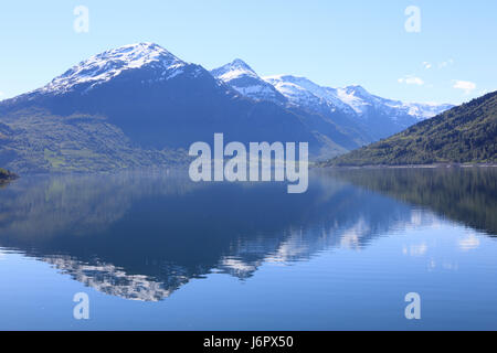 Una meravigliosa splendida giornata di primavera in Loen in Sogn con alberi verdi e montagne innevate. Foto Stock