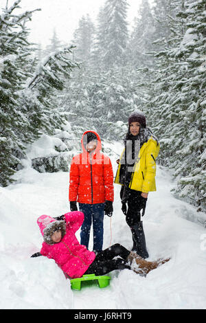 Famiglia avente il divertimento nella neve durante il periodo invernale sul lago Trillium, Oregon Foto Stock