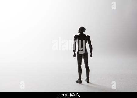 Figurina maschio silhouette in piedi in posa potente cercando su sfondo bianco con copia spazio. Immagine concettuale il convogliamento di concetto di sogni, leade Foto Stock