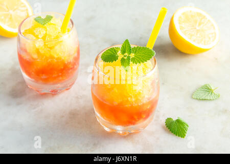 Congelati Granita granita di vino bere rustico tavolo in pietra. In casa italiana Dessert Granita, estivo rinfrescante granita di gradiente a bere con le foglie di menta. Foto Stock