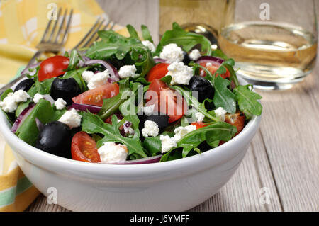 Variazione di insalata greca con la rucola, ciliegia fette, feta e olive Foto Stock