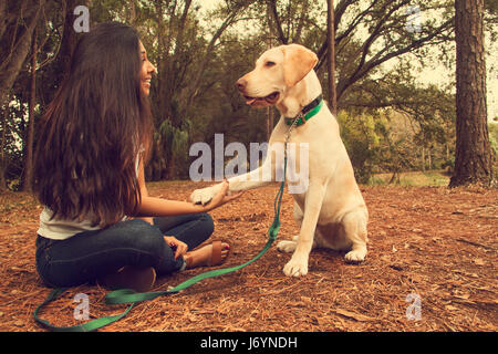 Donna seduta in foresta con un cane, San Pietroburgo, Florida, Stati Uniti Foto Stock