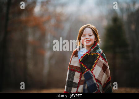 Ritratto di una ragazza avvolta in una trapunta patchwork in piedi in un parco pubblico, USA Foto Stock