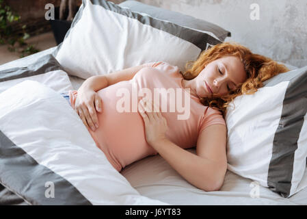 Madre-prendere un pisolino sul letto di casa Foto Stock