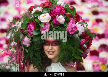 Un modello indossa una peonia personalizzati copricapo floreale sul Primrose Hall stand durante l'anteprima di stampa di RHS Chelsea Flower Show presso il Royal Hospital Chelsea, Londra. Foto Stock