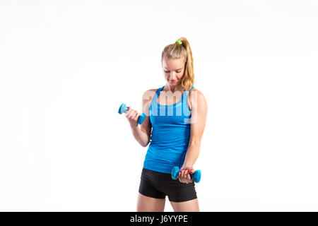 Attraente giovane donna fitness holding manubri. Studio shot. Foto Stock