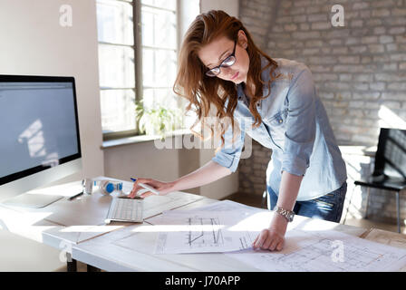 Designer femmina in ufficio a lavorare su progetto degli architetti Foto Stock