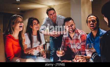 Grande gruppo di amici gustando un bicchiere di vino insieme in un bar. Foto Stock