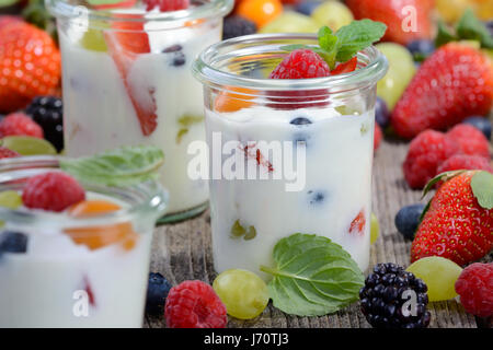 Tre Bicchieri con yogurt bianco e misti di frutta fresca Foto Stock