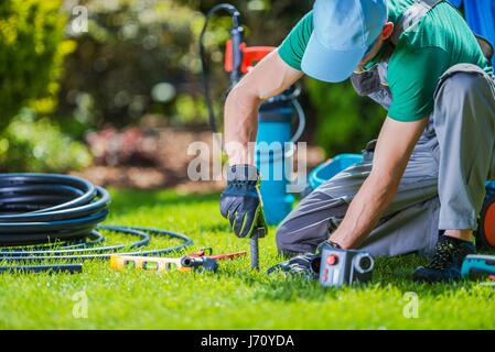 Giardino Impianti di Irrigazione Automatici Installer. Sistema di giardino tecnico al lavoro. Foto Stock