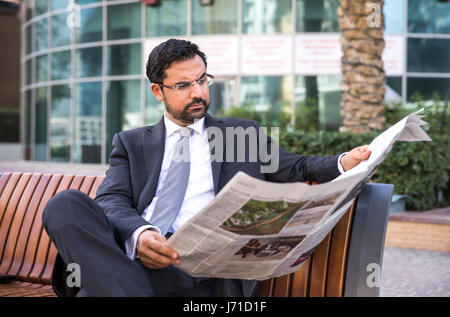 Imprenditore la lettura di una carta nella Marina di Dubai, UAE Foto Stock