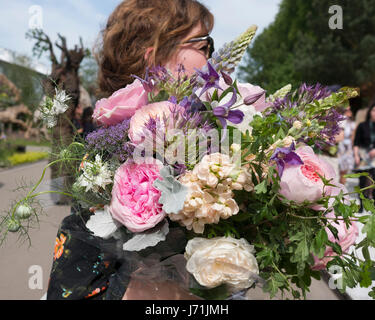 Londra, Regno Unito. 22 Maggio, 2017. Una donna che porta un grande mazzo di rose e peonie al RHS Chelsea Flower Show 2017, Londra, UK Credit: Ellen Rooney/Alamy Live News Foto Stock