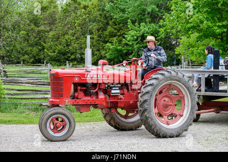 London, Ontario, Canada. 22 Maggio, 2017. Victoria Day, un federale pubblica canadese vacanza con le celebrazioni in onore della regina Victoria il compleanno, anche chiamato Festa della Regina d'Inghilterra. McCormick Deering trattore Farmall, modello H, Made in USA dalla International Harvester Company, usato per tirare un carro con i visitatori a Fawshawe villaggio di pionieri, London, Ontario, Canada. Credito: Rubens Alarcon/Alamy Live News Foto Stock