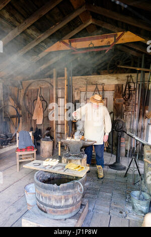 London, Ontario, Canada. 22 Maggio, 2017. Victoria Day, un federale pubblica canadese vacanza con le celebrazioni in onore della regina Victoria il compleanno, anche chiamato Festa della Regina d'Inghilterra. 1800s del fabbro, metalsmith, colono, colono reenactor lavora con strumenti, forgiatura del metallo, forge presso il suo negozio a Fawshawe villaggio di pionieri, London, Ontario, Canada. Credito: Rubens Alarcon/Alamy Live News Foto Stock