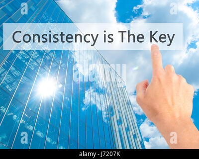 La coerenza è la chiave - Mano premendo un pulsante sul fondo sfocato concetto . Business, tecnologia internet concetto. Stock Photo Foto Stock