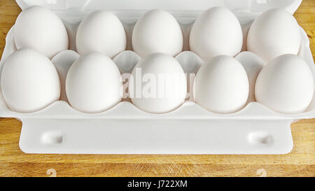 Imballaggio delle uova in una scatola da sopra e close-up su una tavola di legno Foto Stock