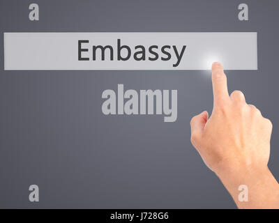 Embassy - Mano premendo un pulsante sul fondo sfocato concetto . Business, tecnologia internet concetto. Stock Photo Foto Stock