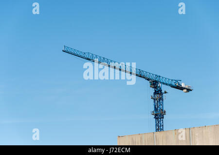 Gru da cantiere contro il cielo blu Foto Stock