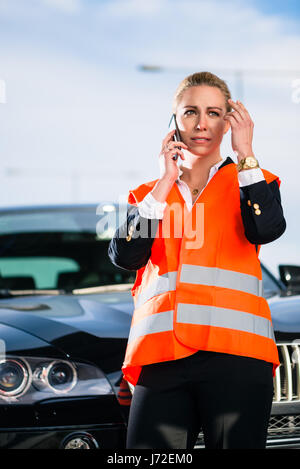 Donna con ripartizione auto chiamando il traino di azienda Foto Stock