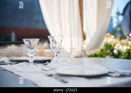 Set da pranzo sul tavolo esterno, focus sui bicchieri, rilassarsi e sentirsi tranquilla Foto Stock