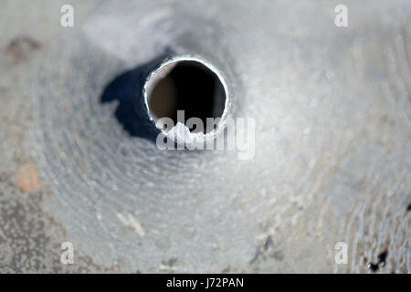 Macro shot di fori di proiettile dopo un tiro al bersaglio in una vaschetta di alluminio. Foto Stock