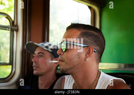 Una persona di fumare una sigaretta su un treno a Cuba. Foto Stock