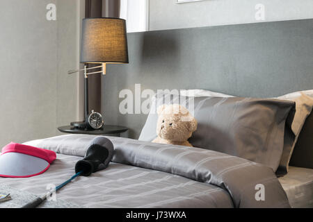 Bambini in camera con bambola e cuscini sul letto di casa Foto Stock