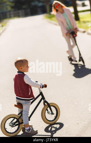 Donna con figlio in scooter Foto Stock