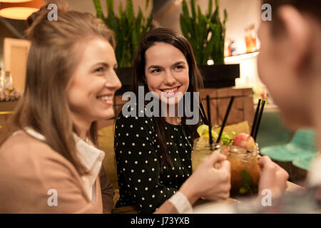 Happy amici tintinnio bevande al ristorante Foto Stock