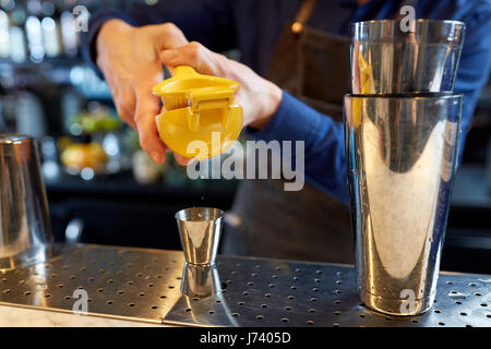 Barista spremendo il succo nella jigger presso il bar Foto Stock