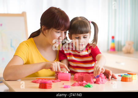 Bambino e terapeuta giocando con il giocattolo di sabbia. Psicologo opere, terapia sabbia. Foto Stock