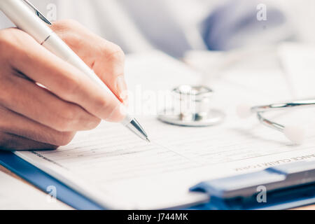 Medico donna riempimento forma medica negli appunti Foto Stock