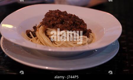 Spaghetti alla bolognese cucina classica italiana. Servito in una ciotola bianca su un piatto di pasta con salsa di manzo e pomodoro a Pattaya Thailandia Foto Stock