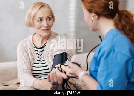 Abile medico utilizzando dispositivi professionali per la misurazione della pressione sanguigna Foto Stock