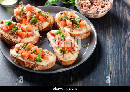 Antipasto bruschetta con tonno, mozzarella e pomodoro. Cucina italiana Foto Stock