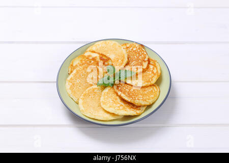 Piastra di fresco frittelle americane in bianco sullo sfondo di legno Foto Stock
