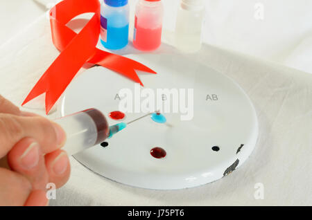Il prelievo di campioni di sangue e di analisi in un laboratorio di biochimica su uno sfondo luminoso con un nastro rosso. Foto Stock