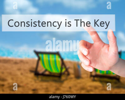 La coerenza è la chiave - Mano premendo un pulsante sul fondo sfocato concetto . Business, tecnologia internet concetto. Stock Photo Foto Stock